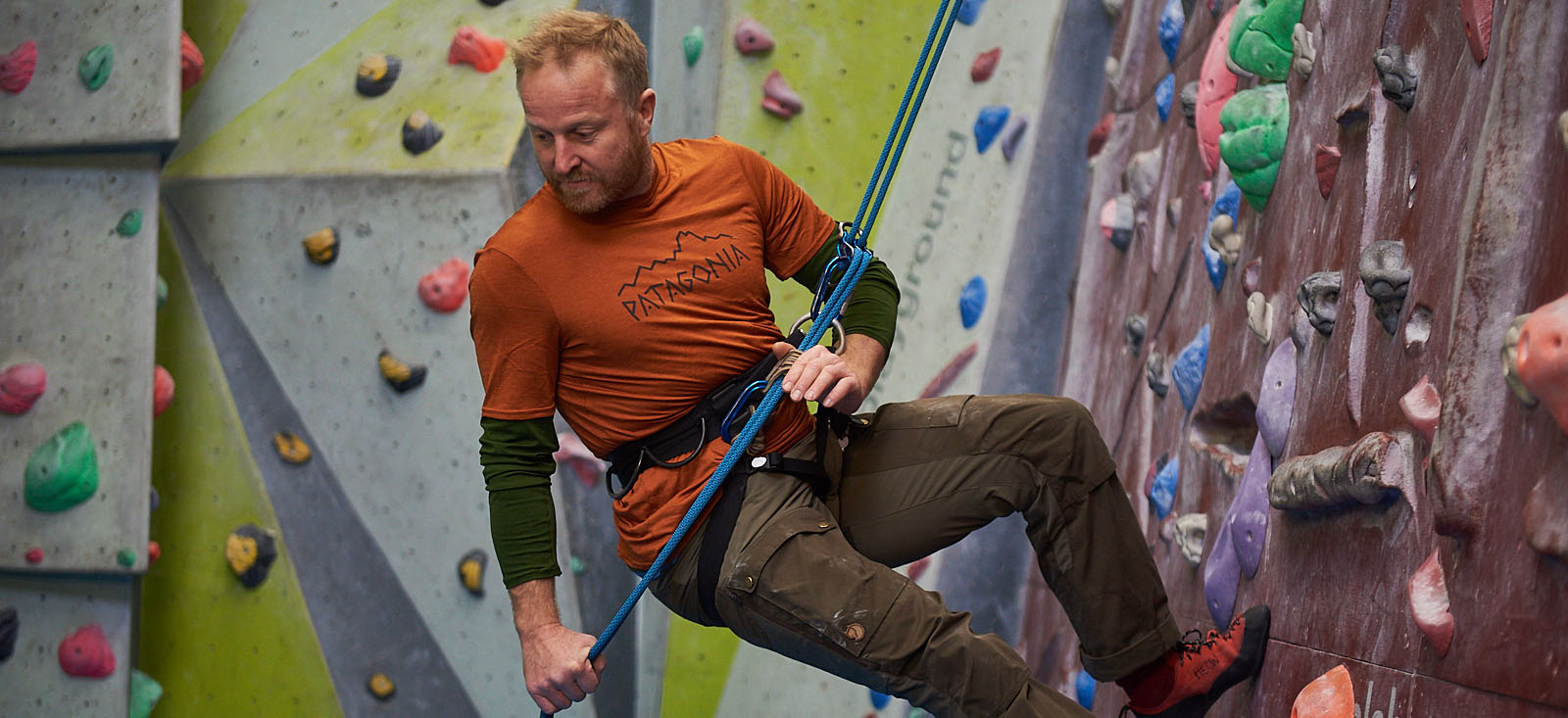 james of mountainwise abseiling on an inddor climbing wall